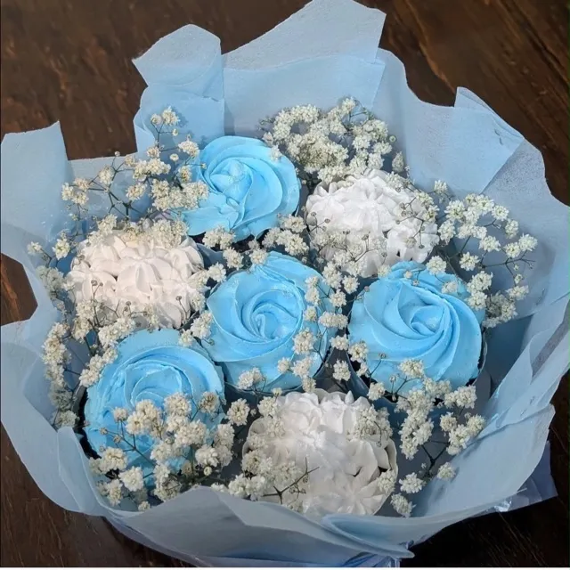 A Cupcake Bouquet — Seven cupcakes wrapped like a bouquet, with alternating sky-blue and white swirled buttercream and sprigs of baby’s breath.